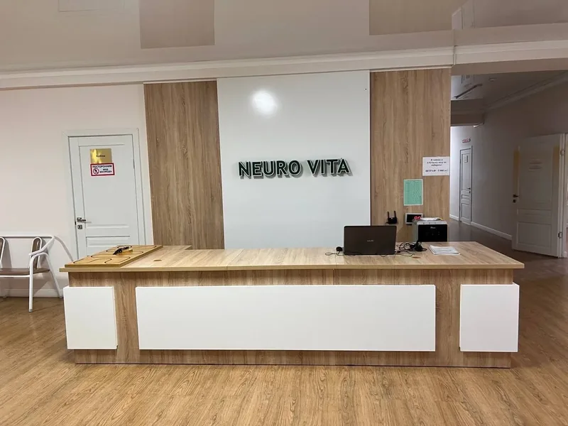Стойка регистрации с вывеской Neuro Vita на стене